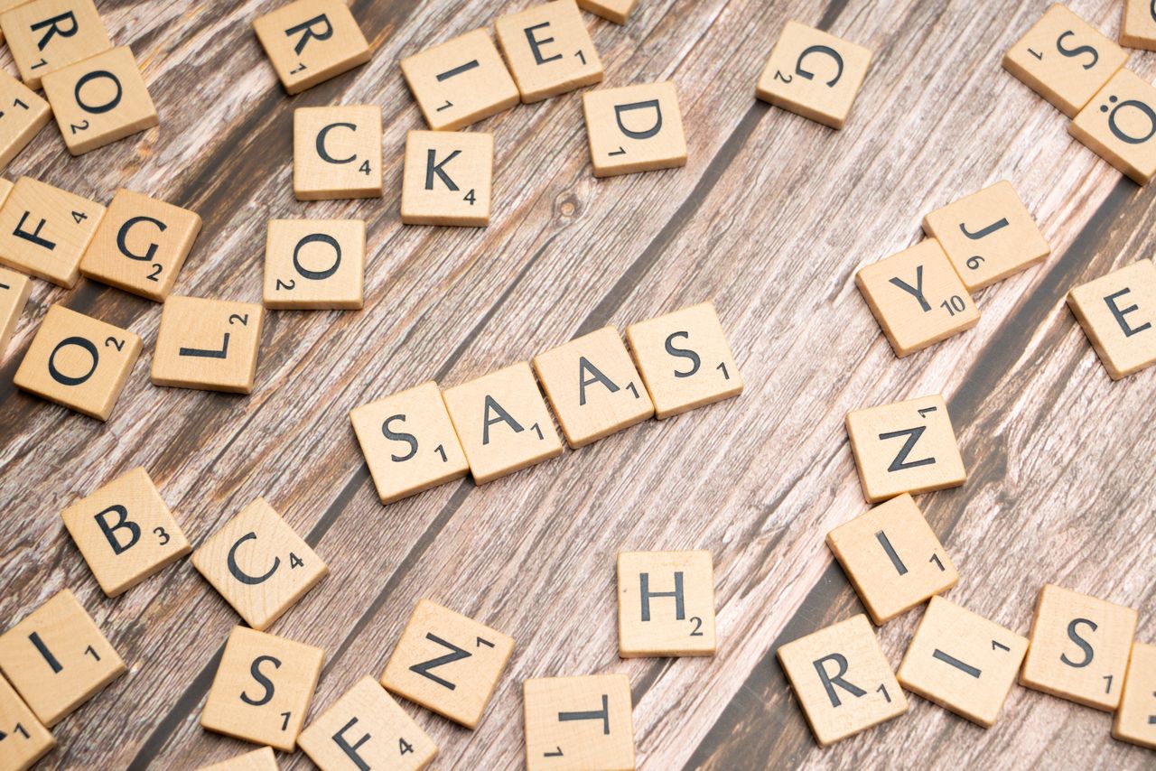 The Art of Drawing Readers In: Your attractive post title goes here Wooden letter tiles spelling SaaS on rustic wood. Ideal for cloud computing and business concepts.