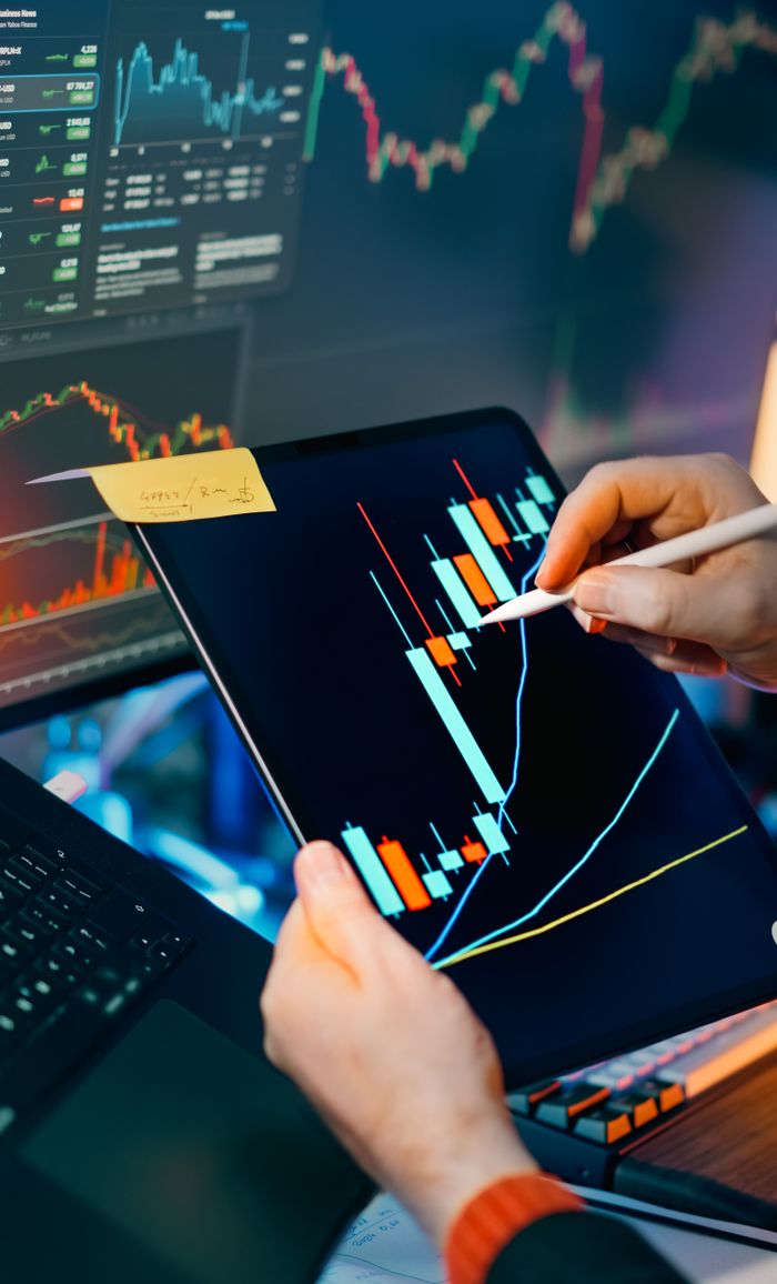 Services Person using a tablet to analyze financial charts for trading insights. Perfect for finance and technology themes.